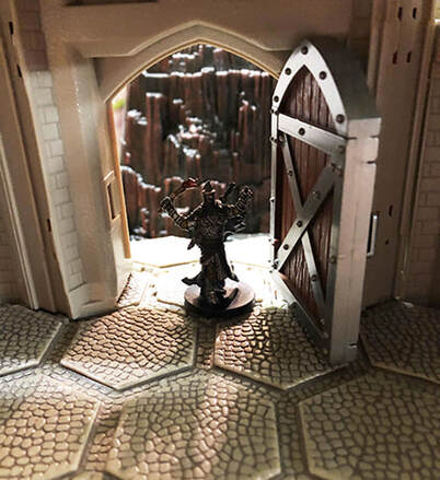 An imposing figure enters castle door.